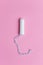 Medical female tampon over a pink background. Menstruation, means of protection