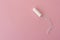 Medical female tampon on a pink background. Hygienic white tampon for women. Cotton swab. Menstruation, protection concept, flat