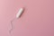 Medical female tampon on a pink background. Hygienic white tampon for women. Cotton swab. Menstruation, protection concept, flat