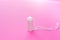 Medical female tampon on a pink background. Hygienic white tampon for women. Cotton swab. Only one tampon on a pink background.