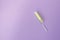 Medical female tampon on a violet background. Hygienic white tampon for women. Cotton swab. Menstruation, protection concept, flat