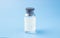 Medical glass bottle with copy space, on a blue background with syringes. Selective focus.