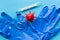 Medical gloves, red model virus and thermometer on blue background.