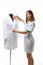 A medical gown hangs on a mannequin, a girl nurse straightens the collar of a gown