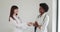 Medical handshake. Doctoral meeting. Two confident doctor standing in hospital and shake their hands. Shot of two