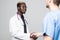 Medical handshake. Doctoral meeting. Two confident doctor and surgeon standing on gray and shake their hands.