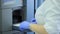 Medical laboratory centrifuge. A female scientist loads vials of liquid into a centrifuge in a laboratory. Scientist