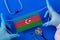 Medical mask with the flag of Azerbaijan in the hands of a doctor and stethoscope, flat lay.