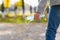 A medical mask in the hands of a teenager on the background of an autumn park.