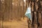 A medical mask hangs on a tree trunk on a blurred forest background