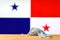 A medical mask lies on the table against the background of the flag of Panama.