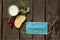 Medical mask a piece of bread and a glass of milk radish on a wooden table at home in the kitchen