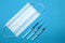 Medical mask and syringes. Blue background. Medical tools for prevention, protection and treatment.
