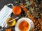 Medical masks with sea buckthorn branches on a dark wooden natural table.The idea of protecting and treating influenza with folk