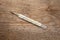 Medical mercury thermometer with a temperature of 37 degrees on a wooden texture. Top view.