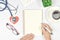 Medical mock-up with blank sheet of paper, clipboard, stethoscope, glasses, heart on doctor desk. Health care concept