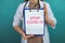 Medical news. Woman holding tablet in the blue cabinet.