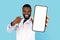 Medical Offer. Black Male Doctor In Uniform Pointing At Big Blank Smartphone