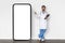 Medical Offer. Male Doctor In Uniform Pointing Finger At Big Blank Smartphone