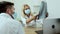 Medical physician doctor in medical mask specialist showing x-ray image of lungs to patient explaining symptoms working