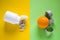 Medical pills with pill bottle opposite orange with measuring tape on yellow and green background