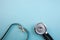 Medical pressure gauge and stethoscope on light blue background, for heart listening, isolated place for text