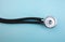 Medical pressure gauge and stethoscope on light blue background, for heart listening, isolated place for text