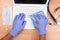 Medical professional with gloved hands disinfecting a laptop computer keyboard from virus, microbes and dirt. CovID-19 Prevention