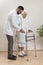 Medical rehabilitation balconies. Grandma learns to walk with the help of a walker and assisted by a nurse.