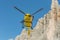 Medical rescue helicopter flying rescue injured climber on the Tre Cime. Italy, Dolomites