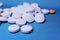 Medical round white and orange tablets, calcium vitamins closeup on blue background. Pills.