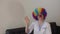 Medical sister in clown\'s wig waves to others.