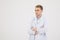 Medical staff. Young sympathetic doctor stands isolated on a white background dressed in a uniform for doctors