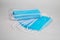 Medical sterile disposable masks. A lot of blue medical masks in one heap on a white background