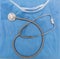 Medical stethoscope on blue surgical coat. Health cardiology and hospital concept, overhead