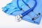 Medical stethoscope and gloves lying on blue uniform doctor close up. The store of medical instruments and instruments