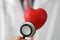 Medical stethoscope instrument listen to red plastic heart