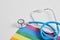 medical stethoscope and lgbtq community flag on gray background copy space