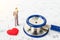 Medical stethoscope and miniature businessman with red heart.