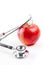 Medical stethoscope on red apple