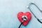 Medical stethoscope and red heart on blue background top view. Healthcare, pulse, heartbeat, medicare and cardiology concept.