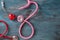 Medical stethoscopes and red heart on wooden background. Cardiology concept