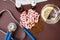 Medical still life: pink pills, fish oil, medical mask, a Cup of water with lemon, stethoscope and medicine in bottles on a brown