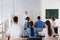 Medical students and professor studying skeleton anatomy in classroom