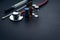 Medical swab, vials and stethoscope closeup on black background