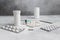 Medical syringe, medicine pills, capsules, vials, on grey concrete background