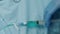 Medical syringe pushes blue liquid into IV tubing or catheter over blue sheet