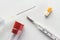 Medical syringe, thermometer, glass tube and pill capsule on white