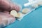 Medical tablets close on the blue background.paramedic hand holds pill. Coronavirus, flu respiratory disease concept