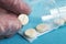 Medical tablets close on the blue background.paramedic hand holds pill. Coronavirus, flu respiratory disease concept